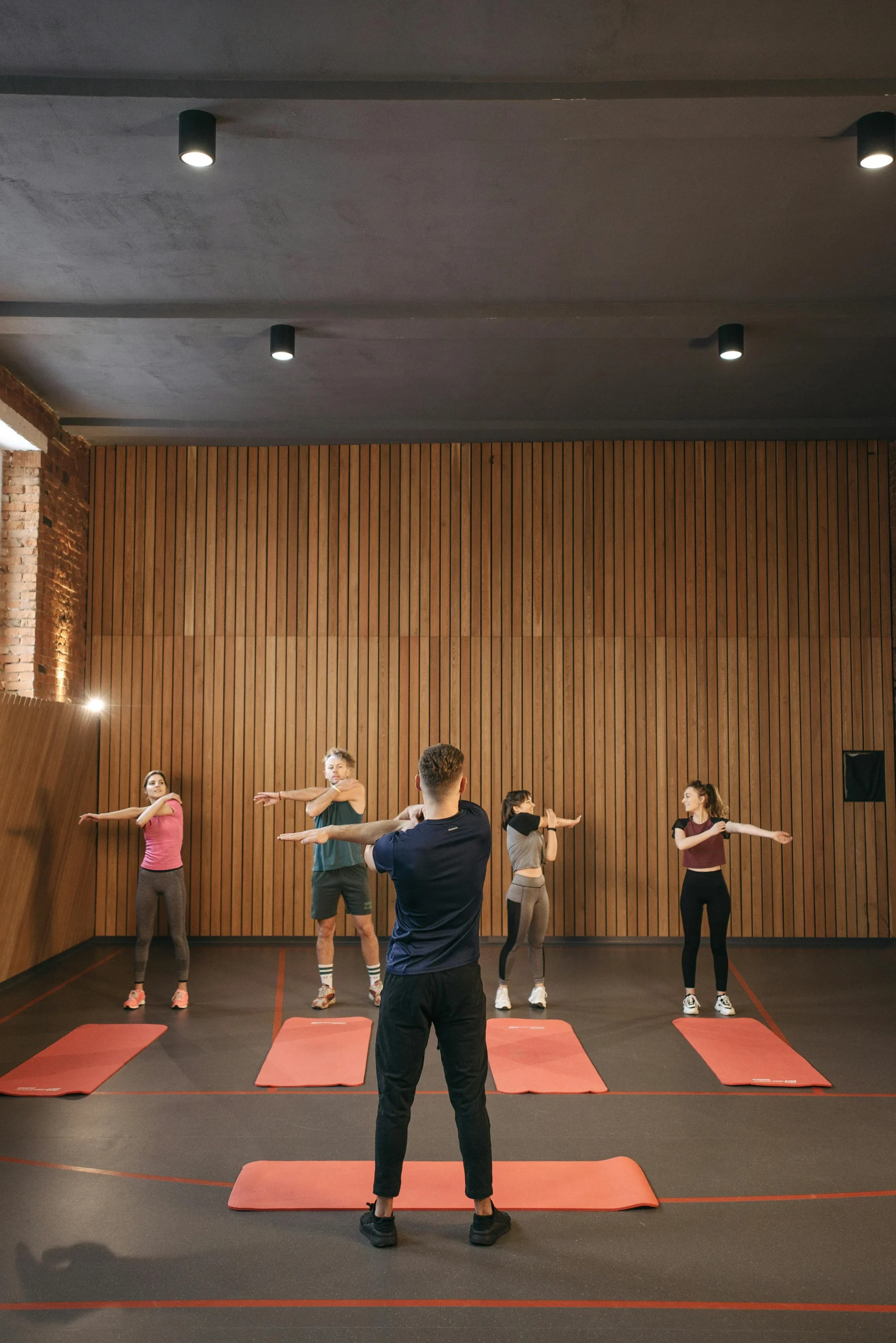 Entrenador personal trabajando con cliente en sesión de fitness boutique